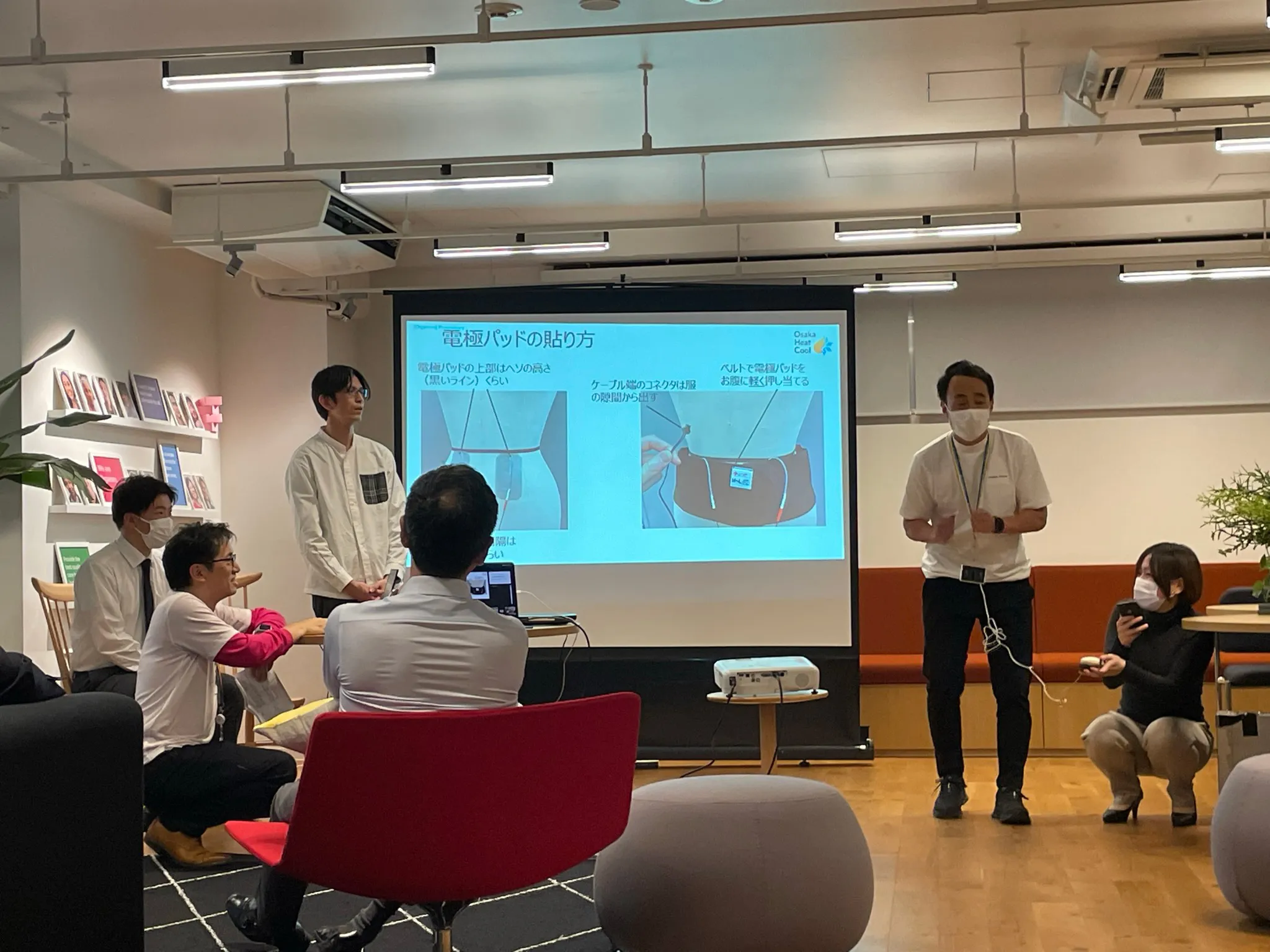 スクリーンに「電極パッドの貼り方」というスライドが投影されている