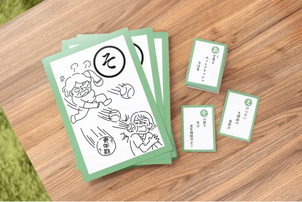 かるた。「そ」の取り札と、「あ」「え」「そ」の読み札が置いてある。読み札の内容は「あせ光る ホットフラッシュ 今は冬」「えげつない 生理前の 食欲が」「その怒り 実は 更年期障害か？」