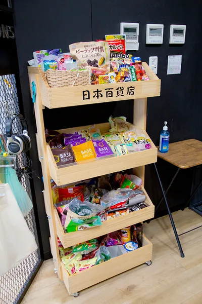 様々な菓子パンや菓子が置いてある4段の木製のラック