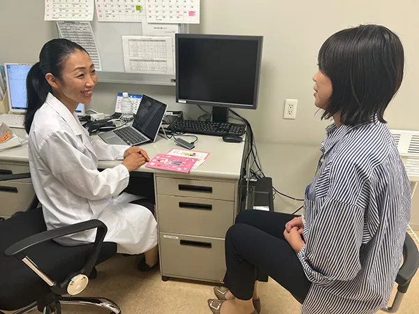 診療所で女性医師の診療を受ける女性